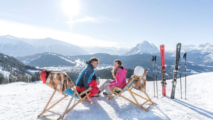 Skifahrer machen Rast in Sonnenliegen