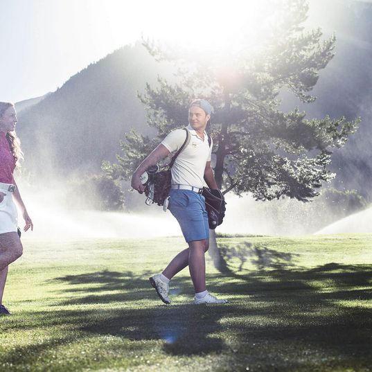 Paar beim Golfen in der Morgensonne