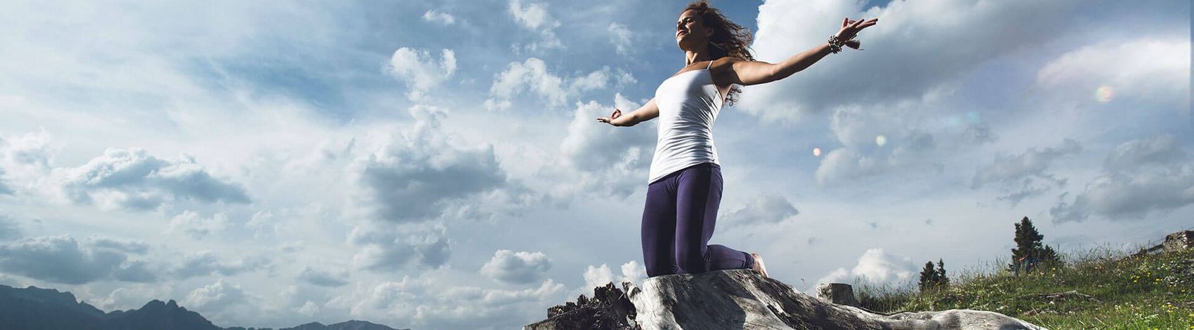 Frau beim Yoga vor Bergpanorama