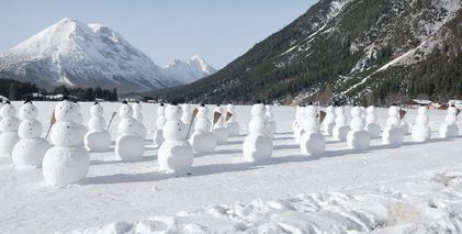 Viele Schneemänner auf Feld
