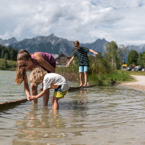 Familie beim Spielen am See